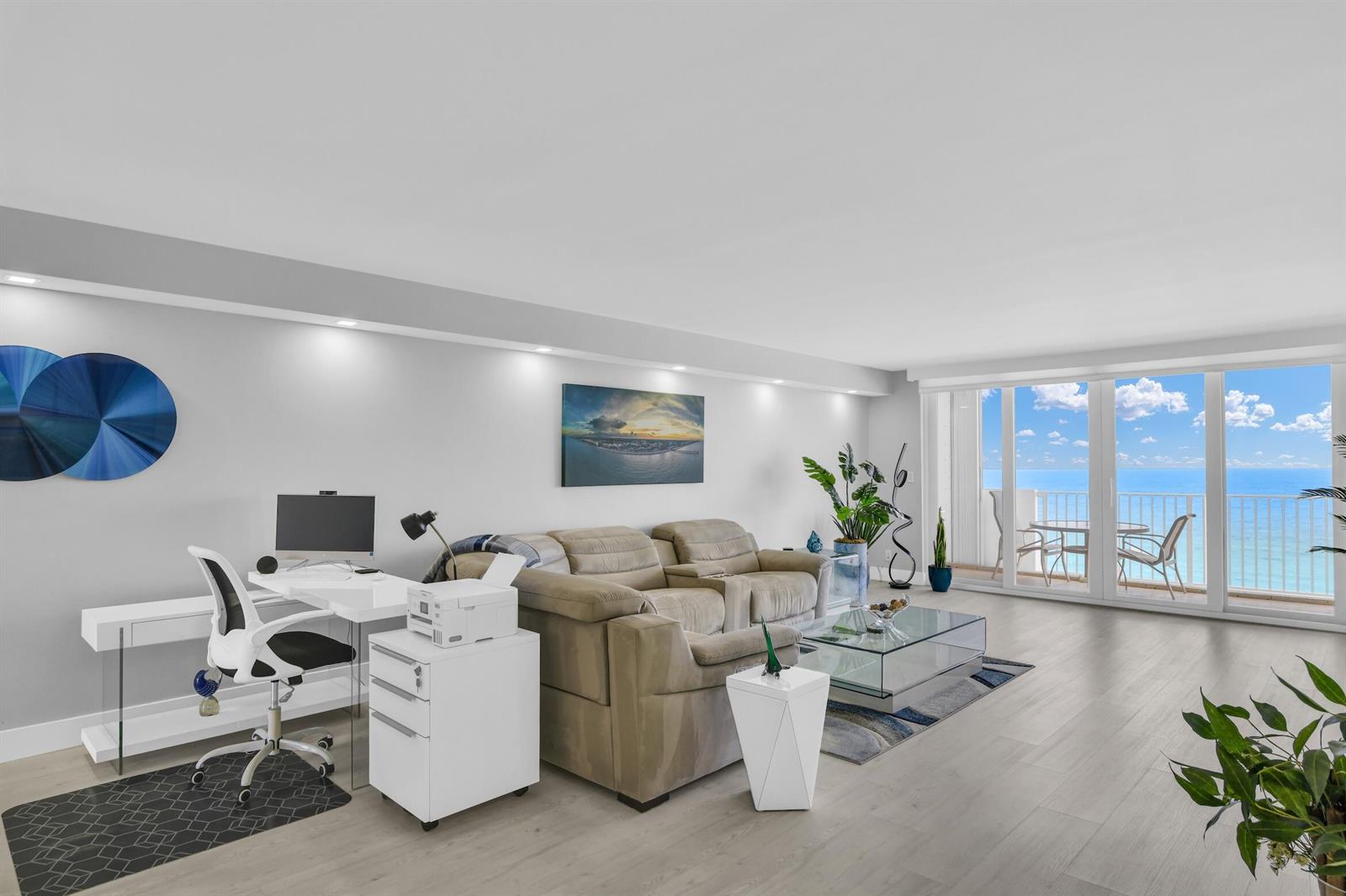 A living room with a desk, sofa, glass coffee table, and balcony overlooking the ocean — 3000 S Ocean Boulevard # 1103, Boca Raton FL 33432, BOCA RATON, FL