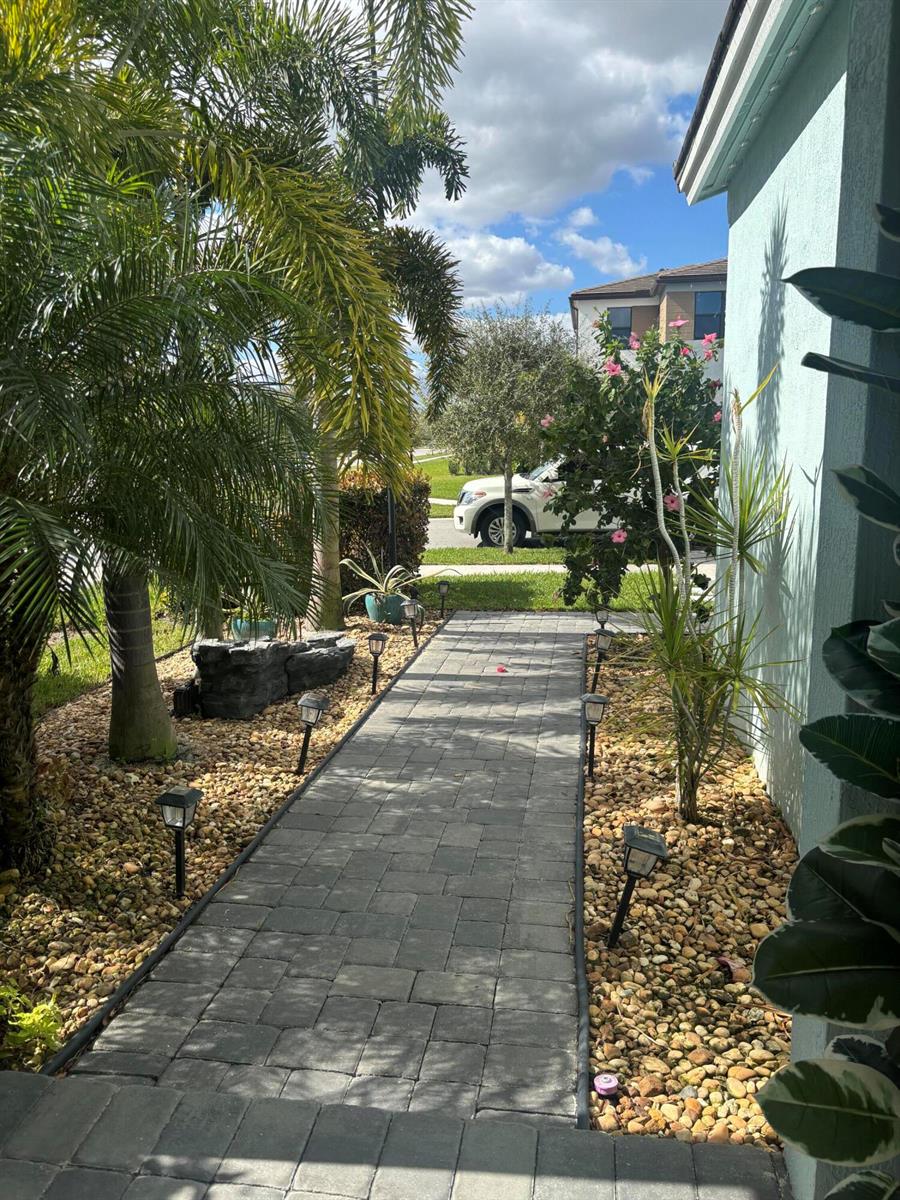 A paved walkway leads past a palm tree and landscaping toward a residential street — 4834 Sand Dollar Drive, Westlake FL 33470, WESTLAKE, FL