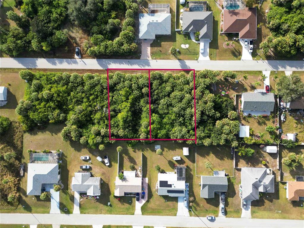 An aerial view shows two adjacent, undeveloped wooded lots outlined in pink between residential streets — 18699 & 18707 ASHCROFT CIRCLE, PORT CHARLOTTE, FL