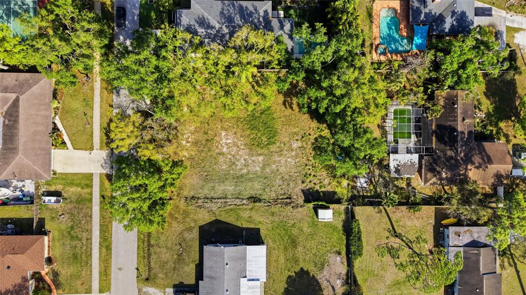 An aerial view shows a suburban neighborhood with houses surrounded by trees and green lawns — 2320 FLORINDA STREET, SARASOTA, FL