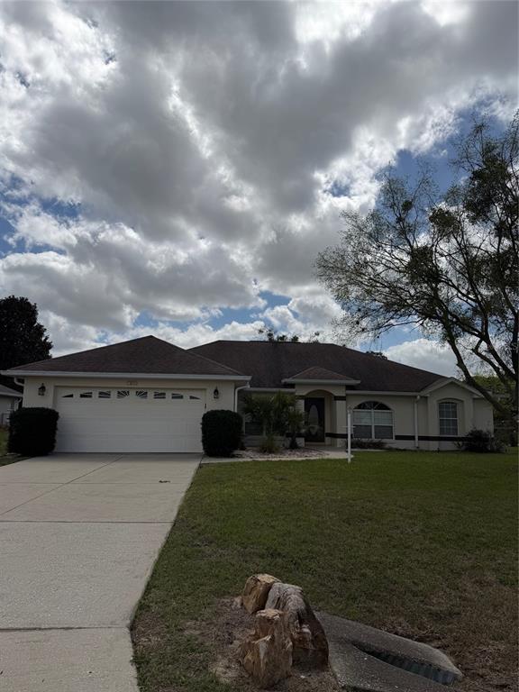 A single-story suburban house with a two-car garage and a large front lawn — 4572 NW 32ND STREET, OCALA, FL