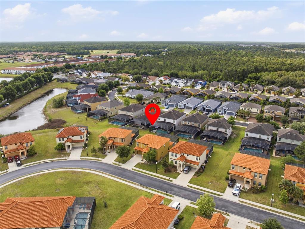 An aerial view shows a suburban neighborhood with houses featuring orange tile roofs and pools — 2621 ROSEMONT CIRCLE, DAVENPORT, FL
