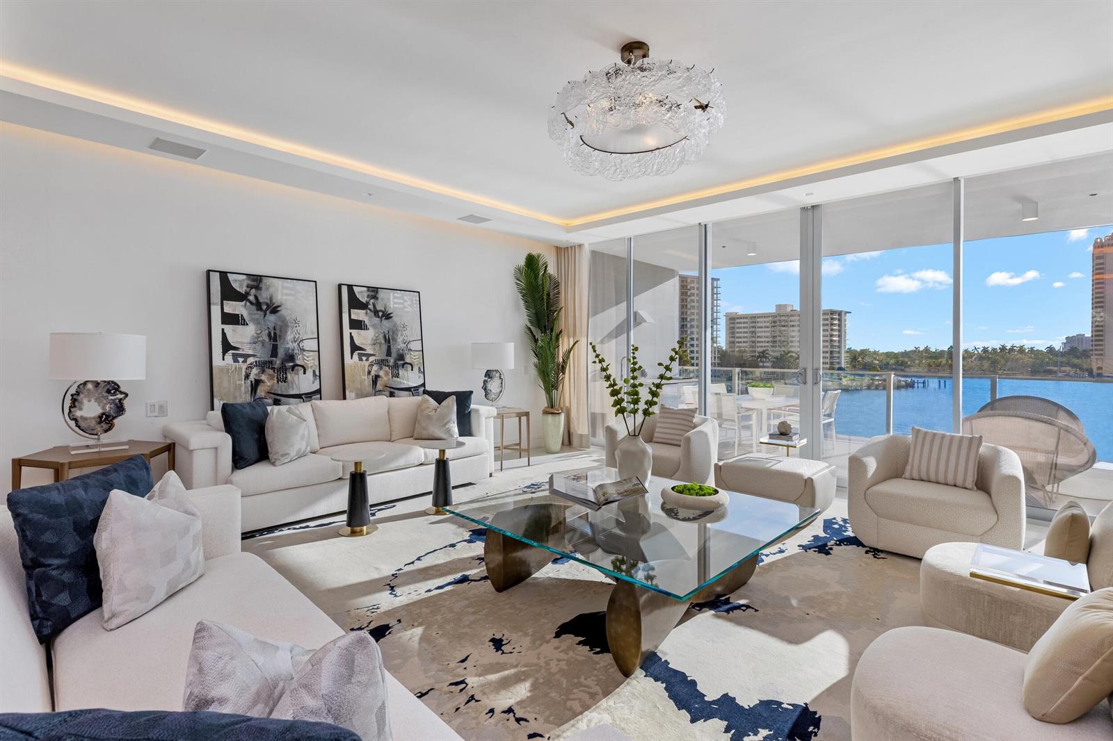 A bright living room features a glass coffee table, white sofas, and floor-to-ceiling balcony windows — 725 S Ocean Boulevard # 402, Boca Raton FL 33432, BOCA RATON, FL