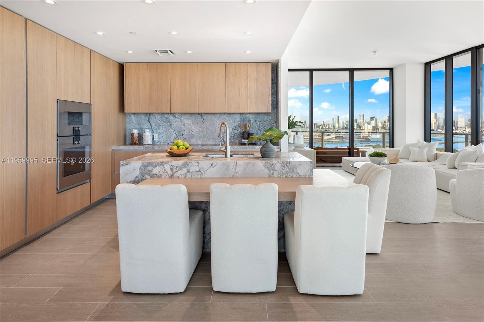 A modern living and dining area features floor-to-ceiling windows overlooking a city skyline at sunset — 500 Alton Rd # 2903, Miami Beach FL 33139, MIAMI BEACH, FL