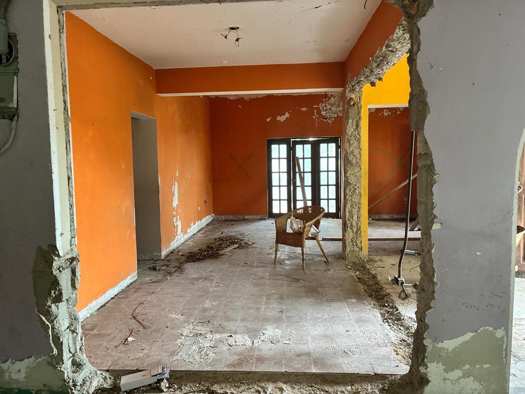 An interior view of a room under renovation with orange walls and exposed concrete edges — 58 CALLE TENIENTE MATTA, SAN JUAN, PR