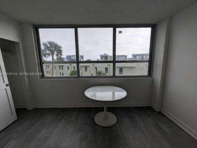A room with gray wood-look flooring, a white pedestal table, and a large window view — 1500 Bay Rd # 310S, Miami Beach FL 33139, MIAMI BEACH, FL
