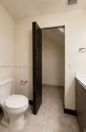 A bathroom with a toilet, a vanity, and an open door leading to a closet — 15668 NW 91st Ct, Miami Lakes FL 33018, MIAMI LAKES, FL