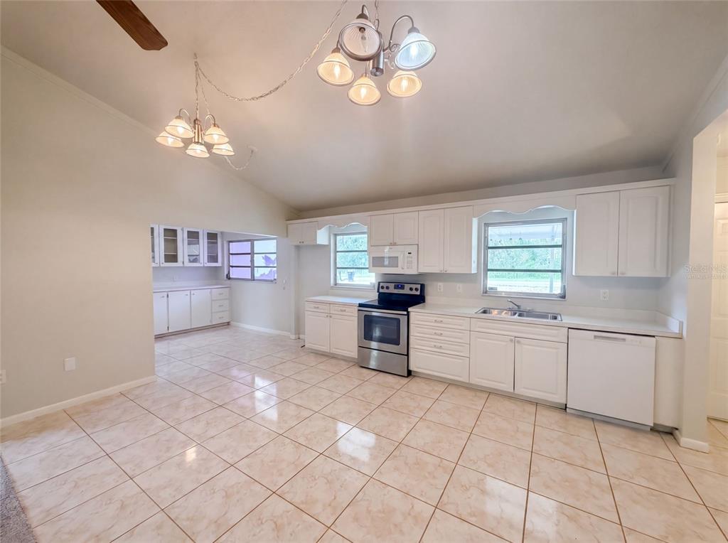 A kitchen with white cabinets, stainless steel appliances, and light-colored tile flooring — 1870 N SEMINOLE ROAD, AVON PARK, FL