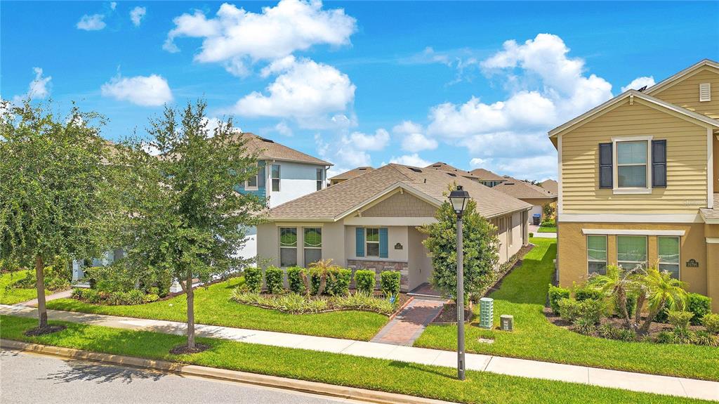 A single-story house with a stone facade and a brick walkway sits between two houses — 16802 OAKBORO STREET, WINTER GARDEN, FL