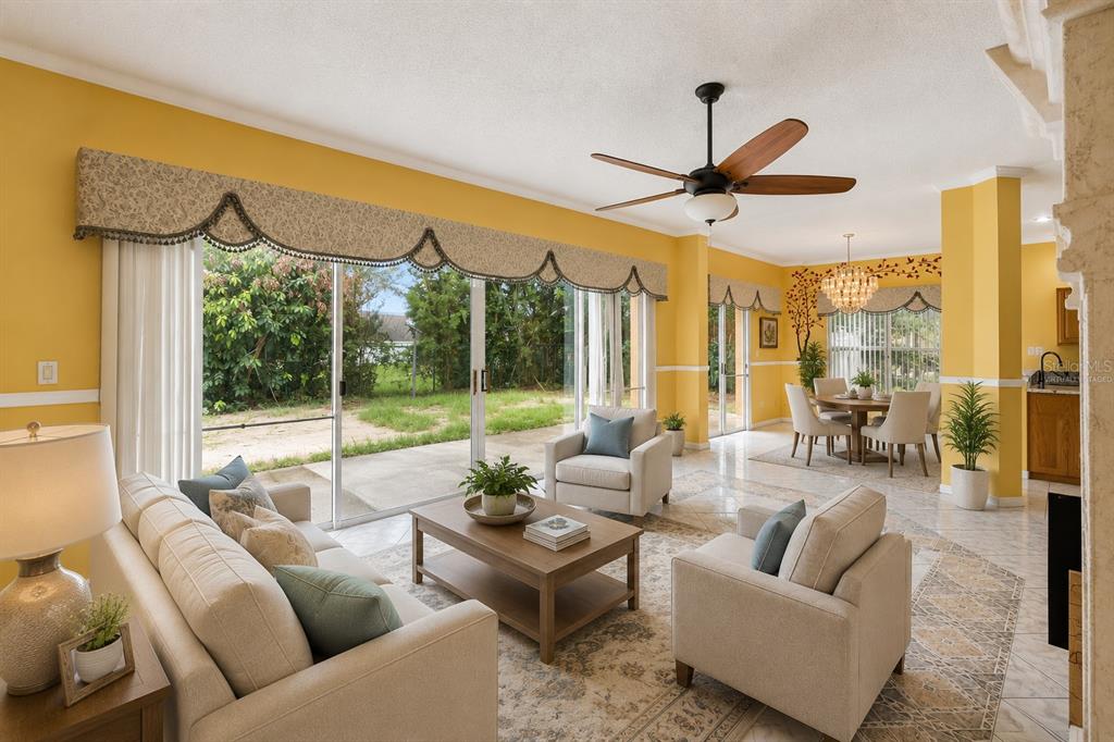 A living room with yellow walls, tile floors, and sliding glass doors leading to a yard — 6415 ABBEYDALE COURT, ORLANDO, FL