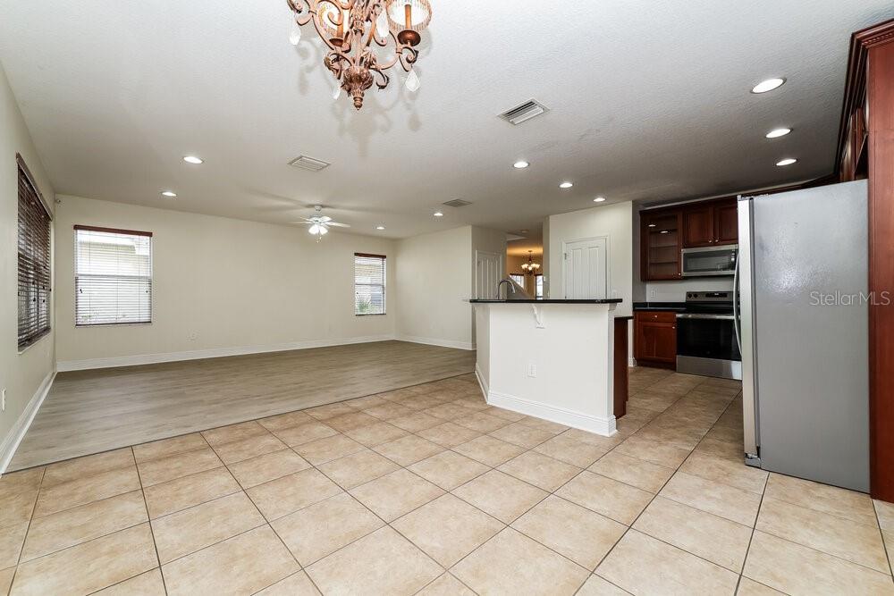 An open-concept kitchen and living area features tile flooring, recessed lighting, and dark wood cabinetry — 209 FERN GULLEY DRIVE, SEFFNER, FL