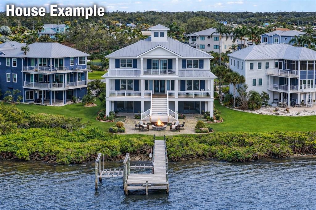 An aerial view shows a wooden dock extending from a grassy lawn toward the water — 5539 2ND AVENUE CIRCLE W, PALMETTO, FL