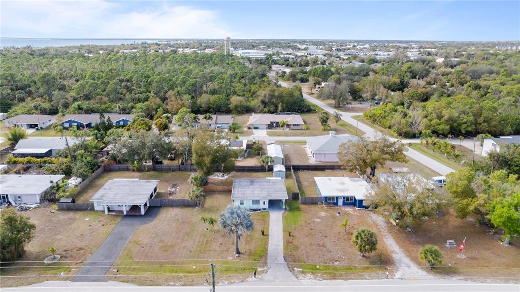 An aerial view shows several single-story residential houses surrounded by trees and grassy yards — 4419 MELBOURNE STREET, PUNTA GORDA, FL