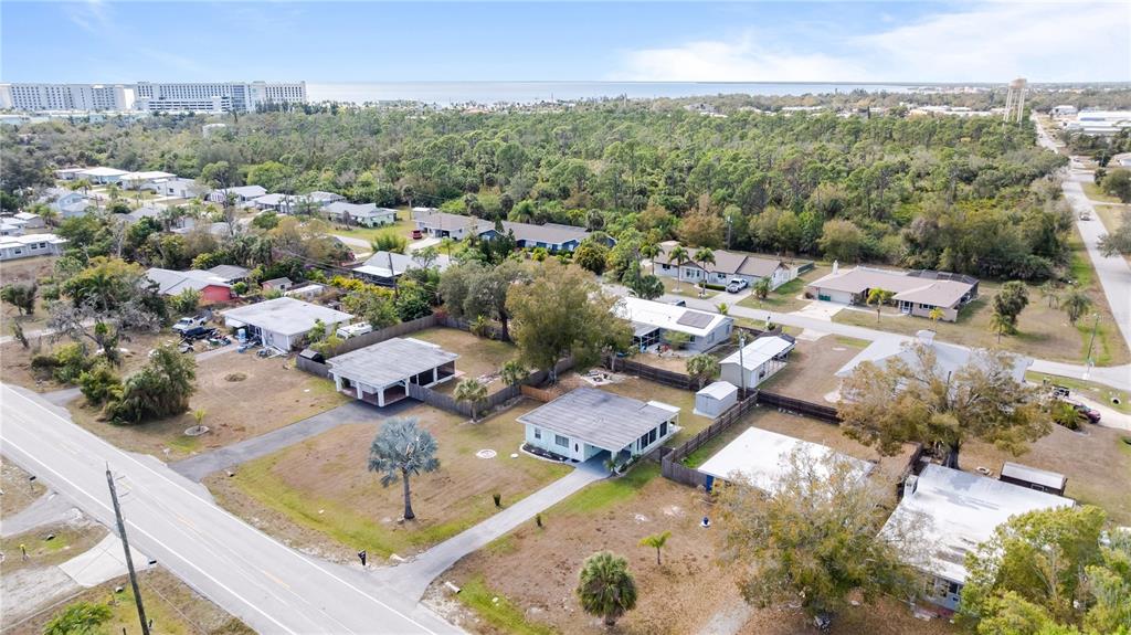 An aerial view shows several single-story houses surrounded by trees and a nearby road — 4419 MELBOURNE STREET, PUNTA GORDA, FL