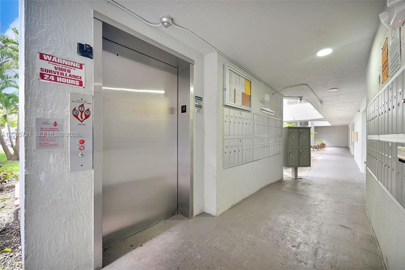 An elevator entrance and rows of mailboxes are located in a covered outdoor hallway — 8255 SW 152nd Ave # 312, Miami FL 33193, MIAMI, FL