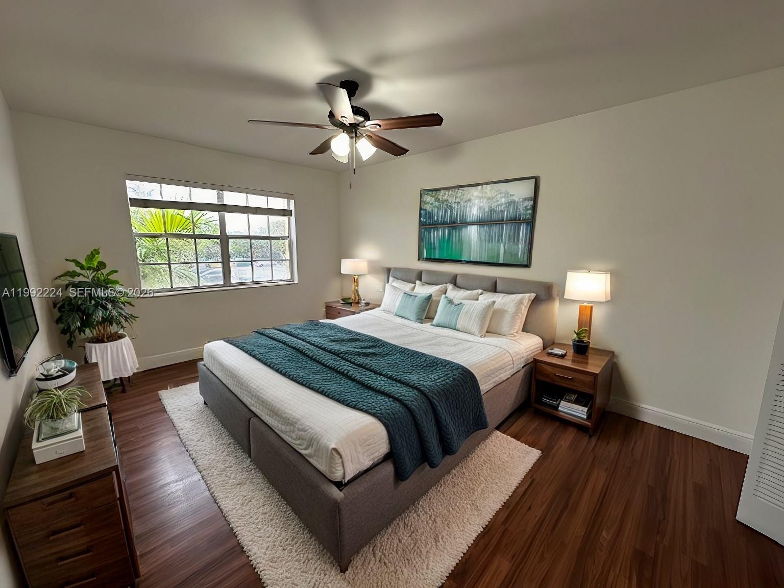 A bedroom features a bed with a teal throw, wood floors, and a ceiling fan — 5400 SW 77 Court # 2R, Miami FL 33155, MIAMI, FL