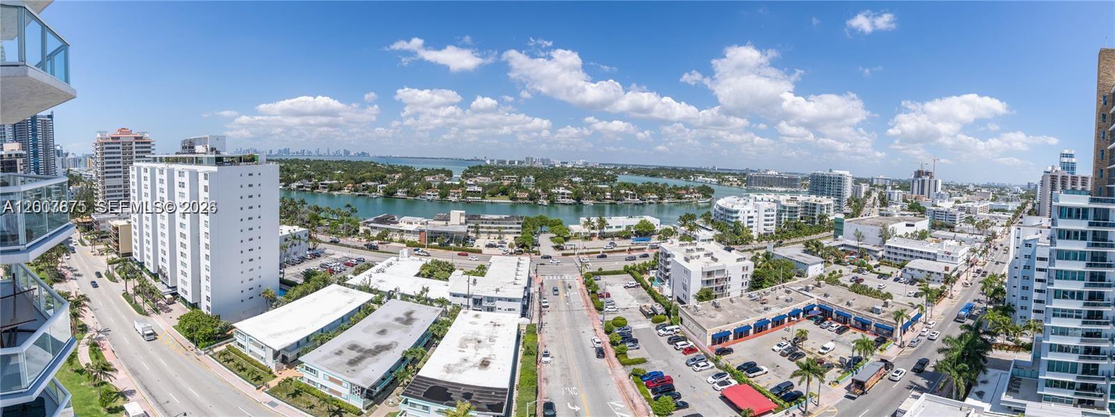 An elevated panoramic view of a coastal city with buildings, a waterway, and streets — 6515 Collins Ave # 1609, Miami Beach FL 33141, MIAMI BEACH, FL