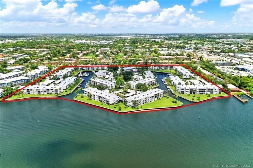An aerial view shows a waterfront condominium complex surrounded by water on three sides — 1950 SW Palm City Road # 305, Stuart FL 34994, STUART, FL