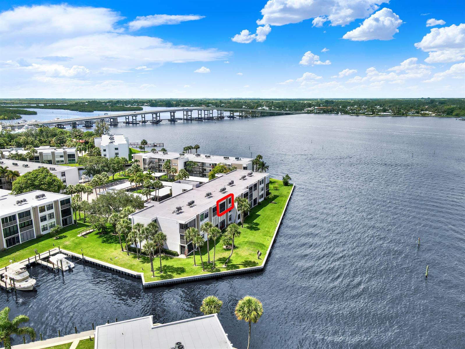 An aerial view shows a multi-story waterfront apartment building with a red-outlined balcony — 1950 SW Palm City Road # 305, Stuart FL 34994, STUART, FL