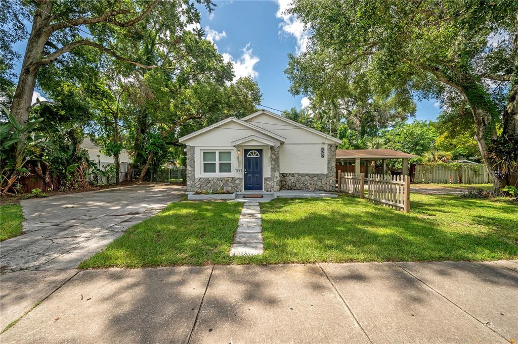 A single-story house with a stone facade, blue front door, and a concrete driveway — 2307 E OSBORNE AVENUE, TAMPA, FL