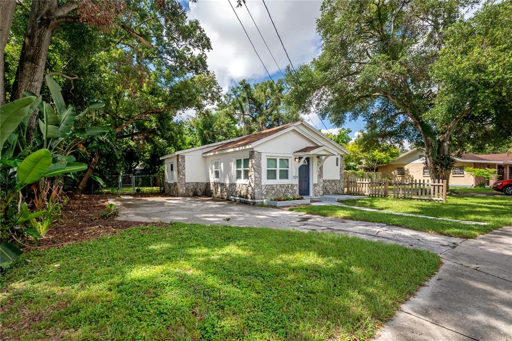 A single-story house with a white exterior, stone accents, and a concrete driveway — 2307 E OSBORNE AVENUE, TAMPA, FL