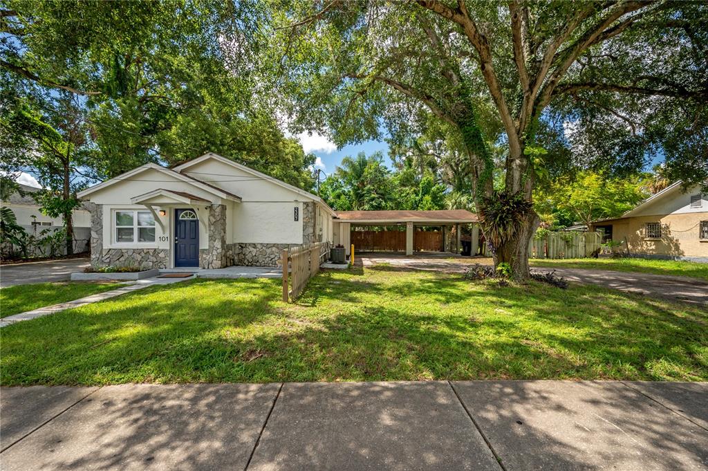 A single-story house with a stone facade, a blue front door, and an attached carport — 2307 E OSBORNE AVENUE, TAMPA, FL