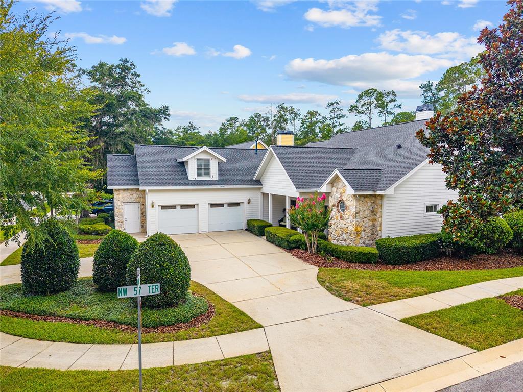 A single-story house with a two-car garage, stone accents, and a landscaped front yard — 5730 NW 52ND PLACE, GAINESVILLE, FL
