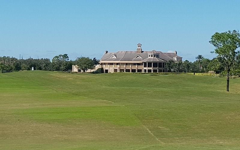 A large multi-story clubhouse building sits atop a grassy hill on a golf course — 13324 HATHERTON CIRCLE, ORLANDO, FL