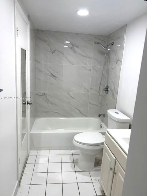 A bathroom featuring a white bathtub, a toilet, and light-colored marble-patterned wall tiles — 3640 NW 9th St # 302, Miami FL 33125, MIAMI, FL