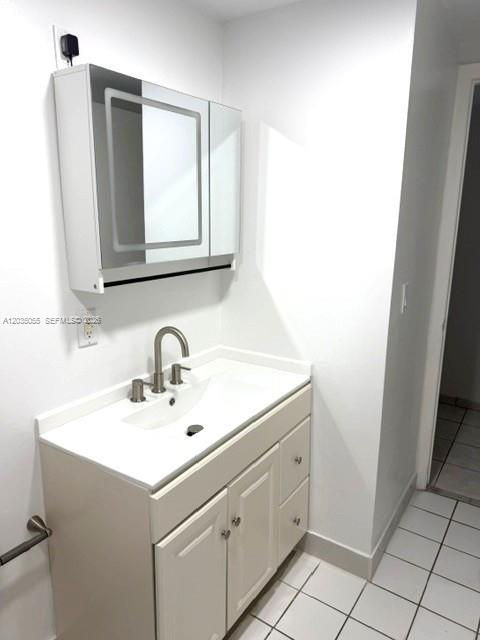 A bathroom vanity with a white sink, chrome faucet, and a mirrored medicine cabinet — 3640 NW 9th St # 302, Miami FL 33125, MIAMI, FL
