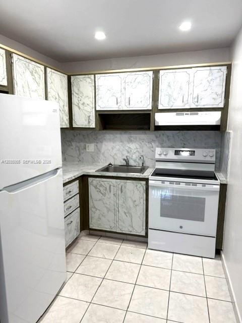 A kitchen features white appliances, marble-patterned cabinets, and light-colored tiled flooring — 3640 NW 9th St # 302, Miami FL 33125, MIAMI, FL