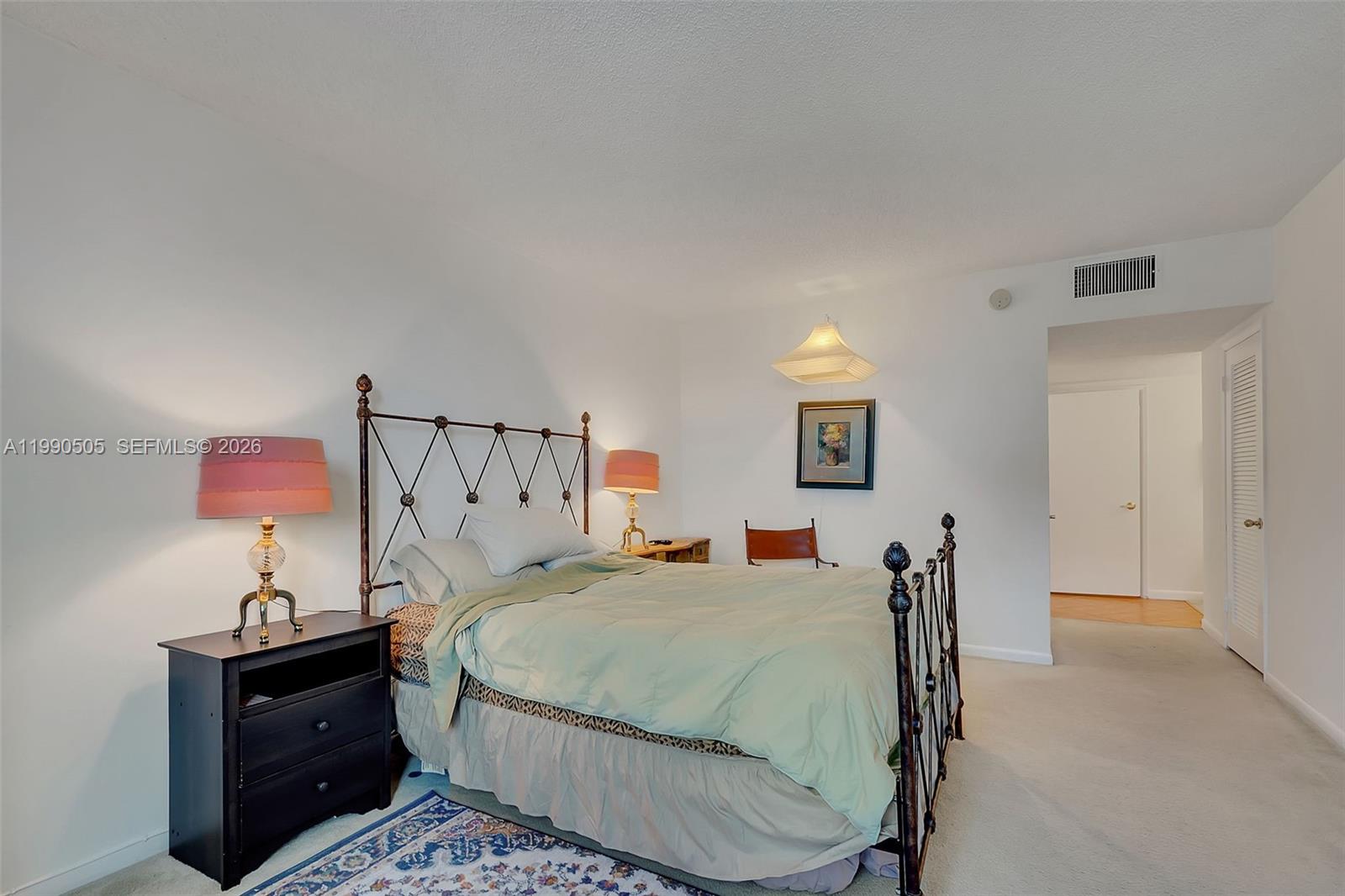 A bedroom features a metal bed frame, two bedside lamps, and a light green comforter — 2301 Collins Ave # 533, Miami Beach FL 33139, MIAMI BEACH, FL