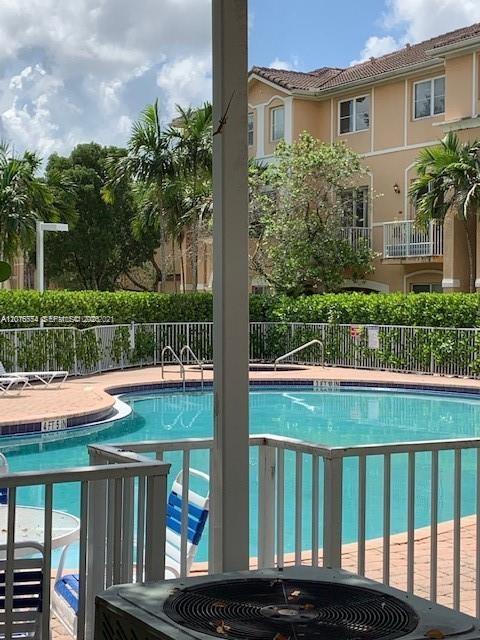 A view of a swimming pool and a multi-story apartment building from a patio — 7100 NW 177th St # 14, Hialeah FL 33015, HIALEAH, FL
