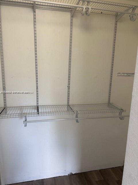 A walk-in closet features white wire shelving and a hanging rod mounted on the wall — 7100 NW 177th St # 14, Hialeah FL 33015, HIALEAH, FL