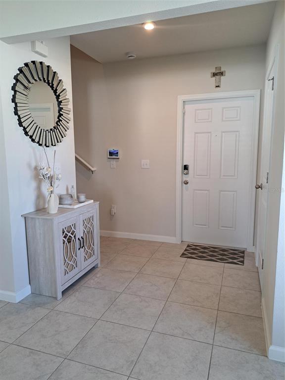 An entryway features a light-colored cabinet, a sunburst mirror, and a white front door — 1508 MAJESTIC LANE, WINTER HAVEN, FL