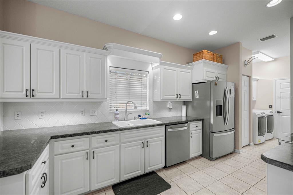 A kitchen with white cabinets, dark countertops, stainless steel appliances, and tile flooring — 2197 NW 55TH AVENUE ROAD, OCALA, FL
