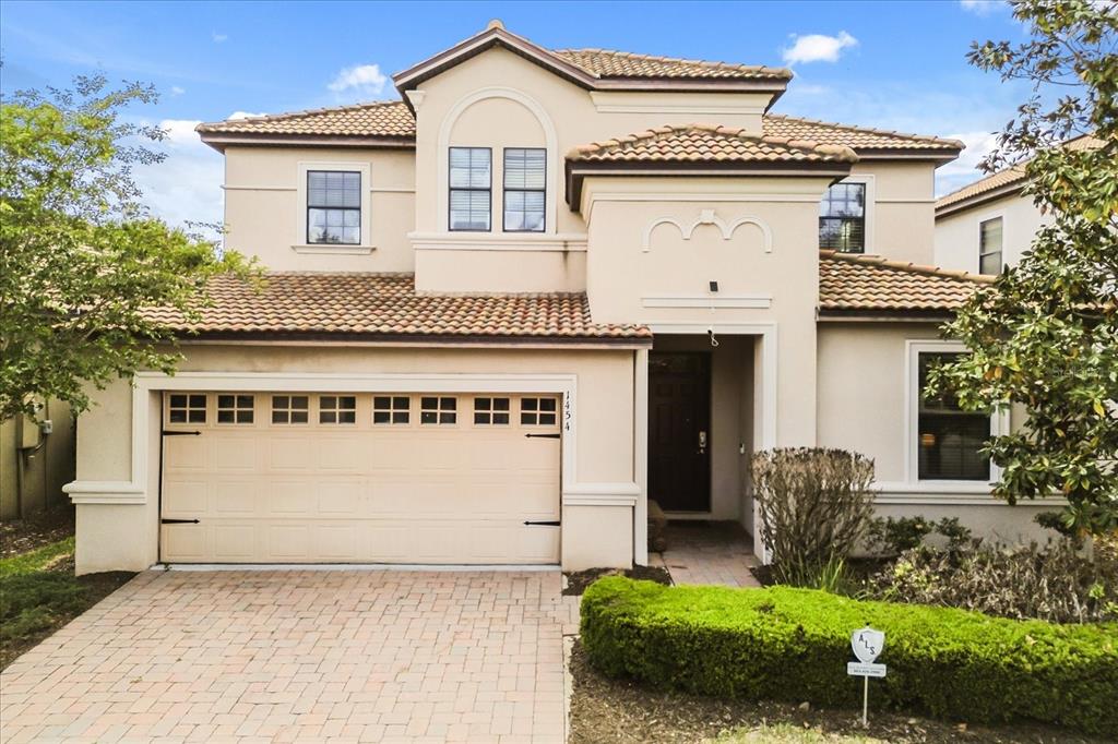 A two-story stucco house with a tiled roof and a two-car garage — 1454 MYRTLEWOOD STREET, DAVENPORT, FL