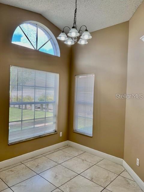 A dining nook with tile floors, a chandelier, and windows with blinds — 3072 STILLWATER DRIVE, KISSIMMEE, FL