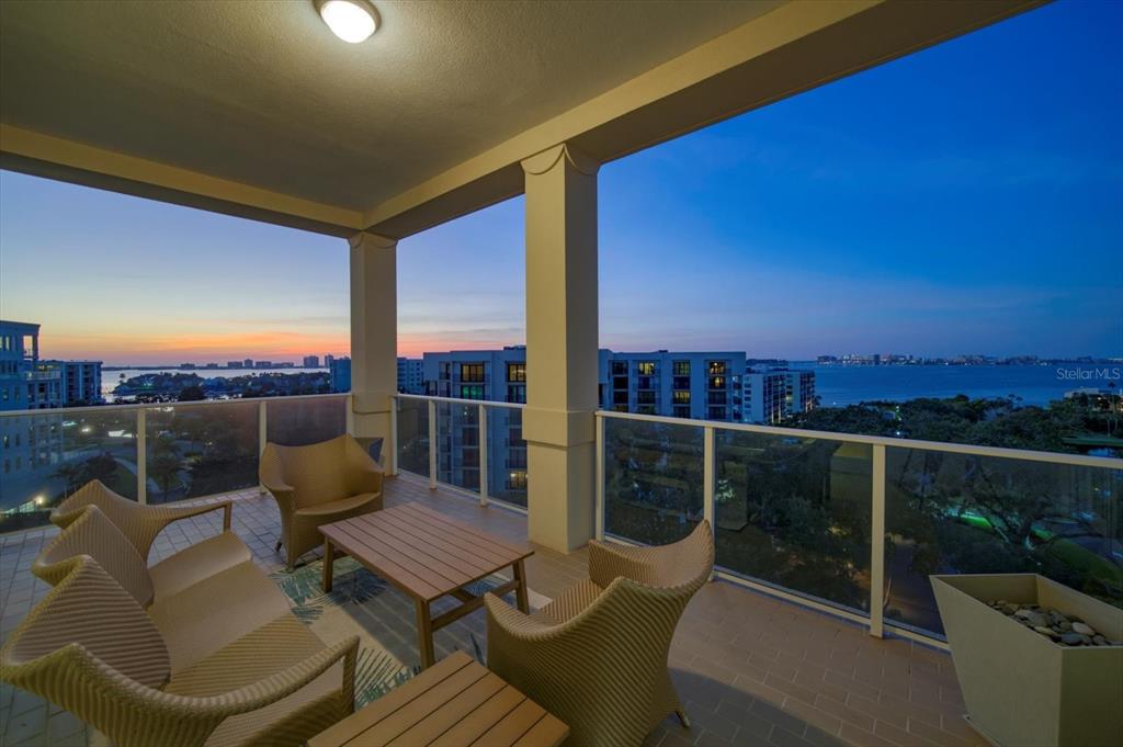 An aerial view shows a multi-story residential building complex surrounded by green space and water — 8 PALM TERRACE UNIT 605, BELLEAIR, FL
