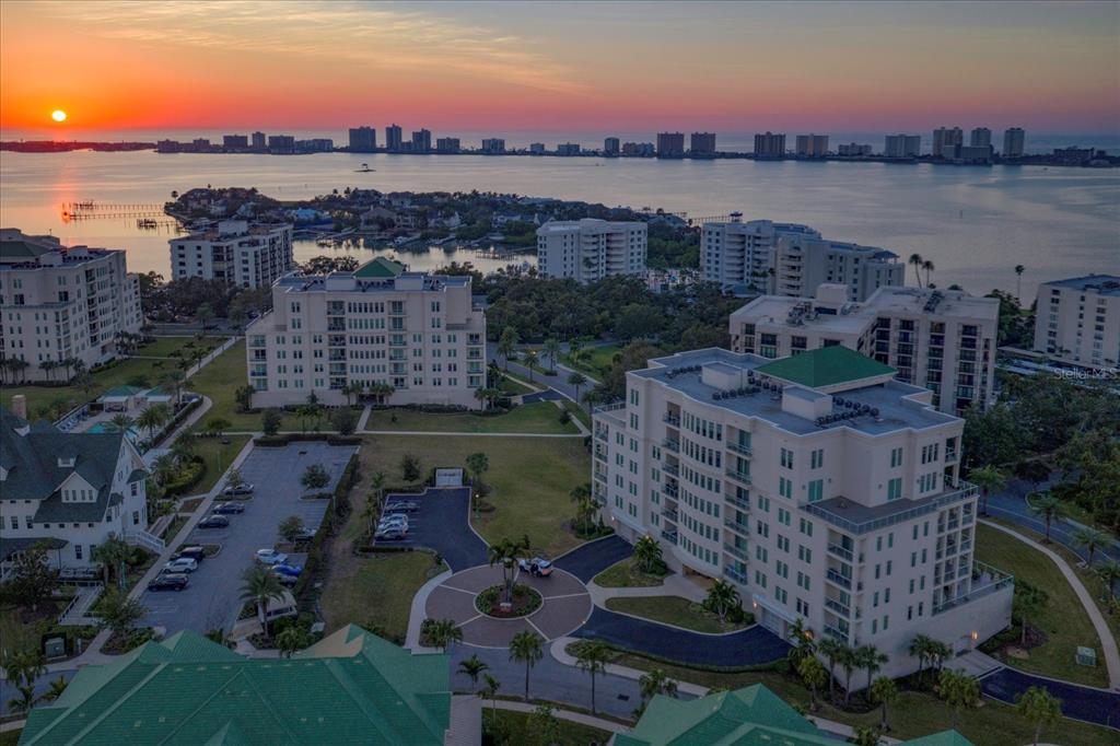 An aerial view of a multi-story residential building with balconies and a paved driveway — 8 PALM TERRACE UNIT 605, BELLEAIR, FL