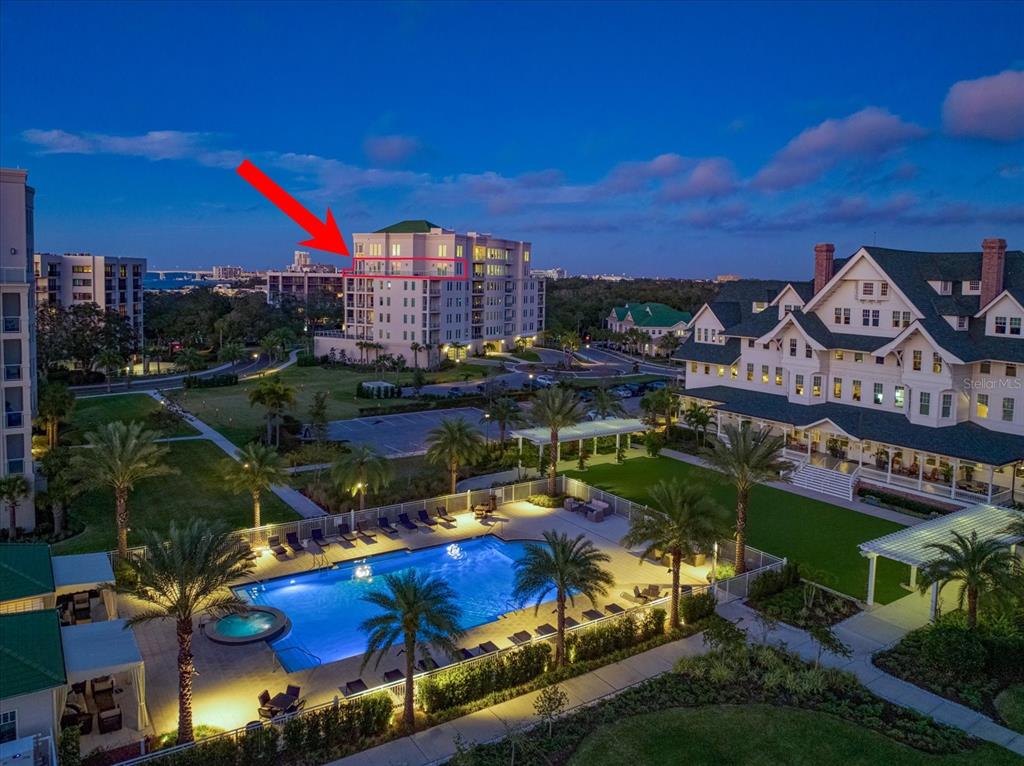 An aerial view of several multi-story apartment buildings near a bay at sunset — 8 PALM TERRACE UNIT 605, BELLEAIR, FL