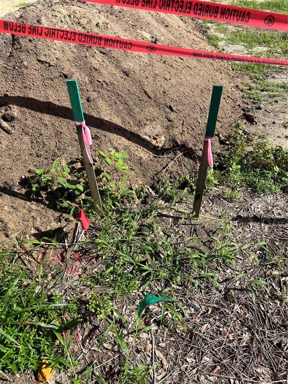 Two wooden stakes with pink ribbons stand in front of a pile of dirt — 276 NW 12TH AVE, GAINESVILLE, FL