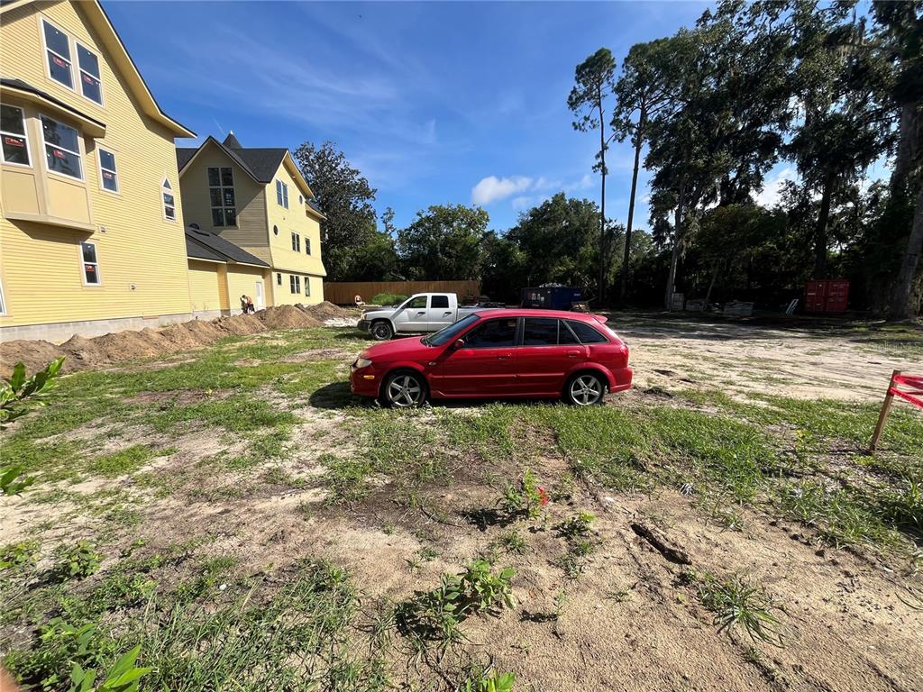 A red hatchback and a white pickup truck are parked on a dirt lot — 276 NW 12TH AVE, GAINESVILLE, FL