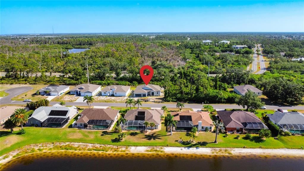 An aerial view shows a suburban neighborhood with houses, a lake, and a red location pin — 9040 EVELYN ROAD, ENGLEWOOD, FL