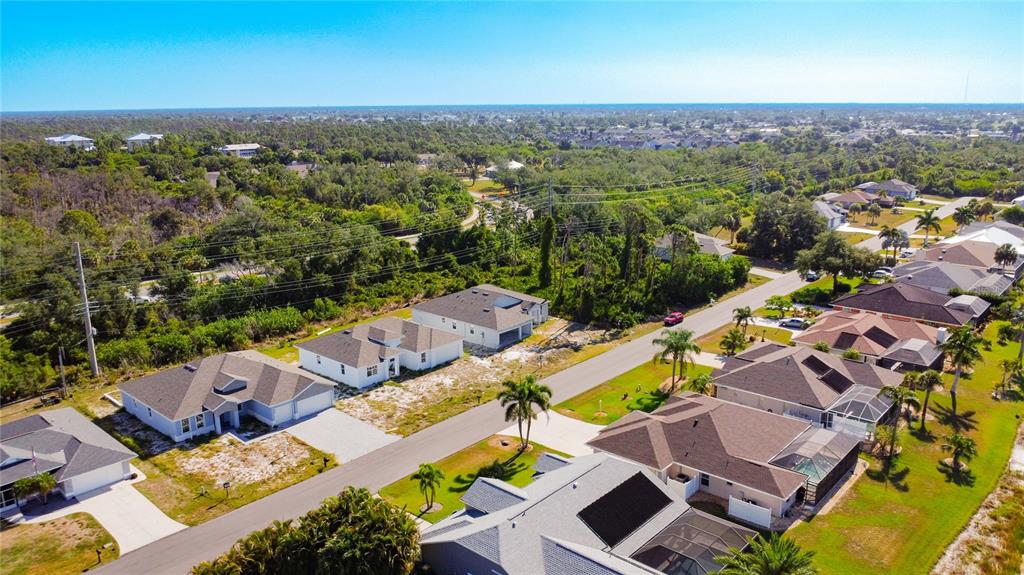 An aerial view shows several suburban houses with driveways and lawns along a paved road — 9040 EVELYN ROAD, ENGLEWOOD, FL