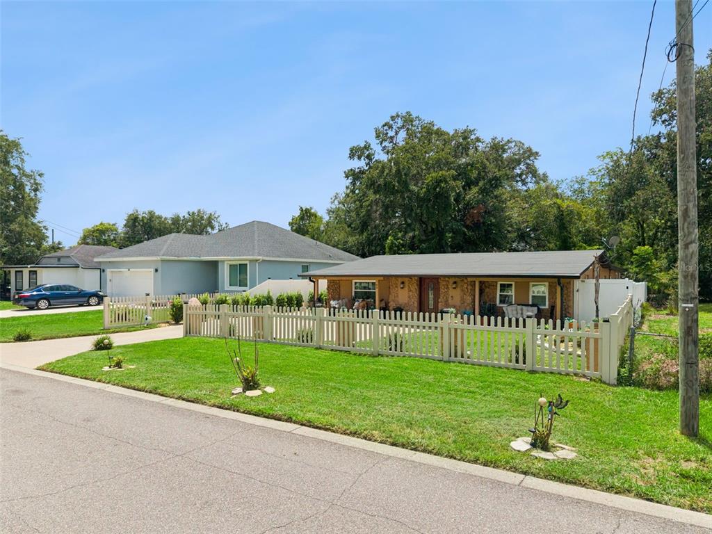 A single-story house with a light-colored fence, a green lawn, and a paved driveway — 90 N GOLDWYN AVENUE, ORLANDO, FL
