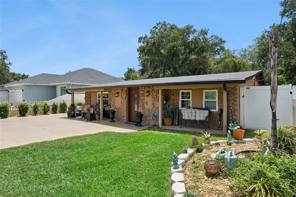 A single-story house with a stone facade, a covered porch, and a concrete driveway — 90 N GOLDWYN AVENUE, ORLANDO, FL