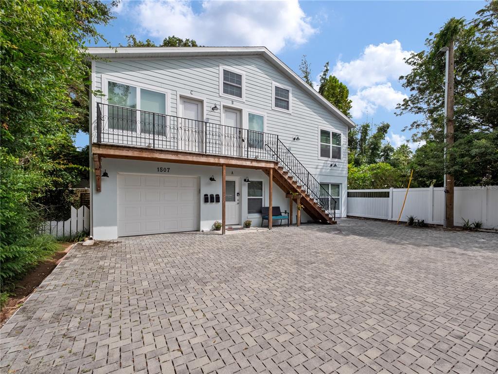 A two-story light blue building with a paved driveway, garage, and exterior staircase — 1505 CATHERINE STREET, ORLANDO, FL