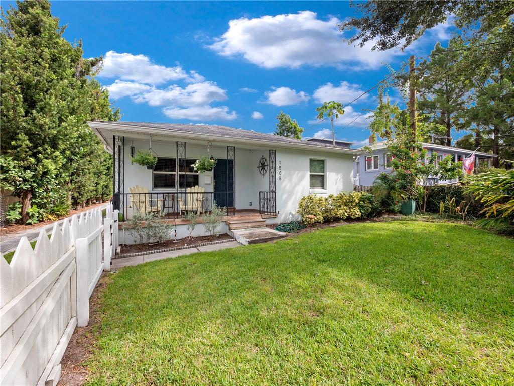 A single-story white house with a front porch and a white picket fence — 1505 CATHERINE STREET, ORLANDO, FL