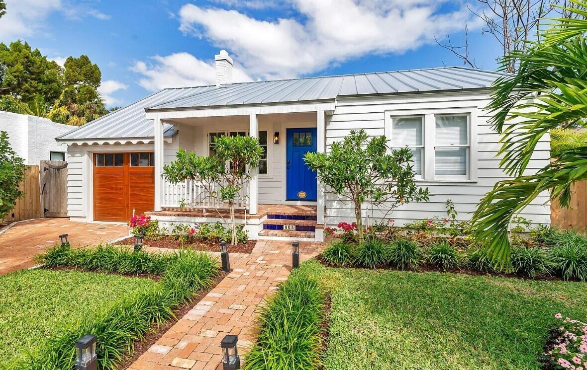 A white cottage with a metal roof, blue front door, and brick walkway — 803 Kanuga Drive, West Palm Beach FL 33401, WEST PALM BEACH, FL